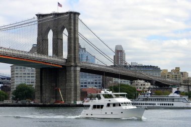 Brooklyn Köprüsü, New York, New York, ABD 'nin arka planında 17 Eylül 2010' da East River 'da beyaz motorlu yat yolda.