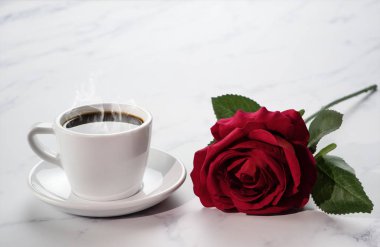 Bir fincan koyu kahvenin arka planında bir sürü kırmızı kahve.