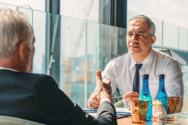 portrait of businessman with grey hair having business talk with