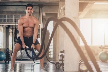 Kafkasyalı genç adam salonda iple idman yapıyor.