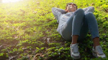 Kafkas güzeli genç bayan parktaki yeşil çimlerde dinleniyor.