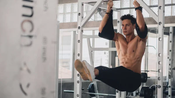 Caucasiano homem forte fazendo exercício na barra horizontal no ginásio clu — Fotografia de Stock