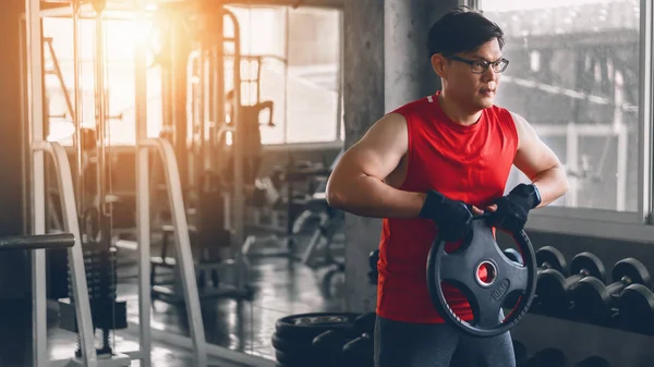 Ásia forte homem fazendo exercício com levantamento de peso no ginásio clube — Fotografia de Stock