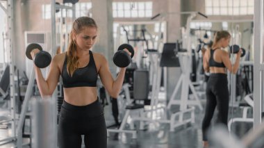 Kafkasyalı kadın spor yaparken halterleri kaldırıyor.