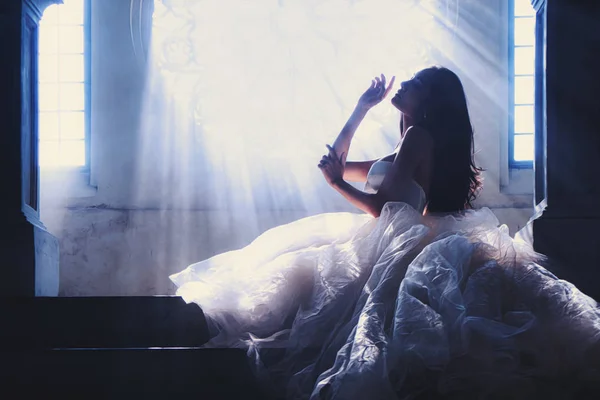 Silhouette portrait of bride in white dress sitting on stairs in — ストック写真