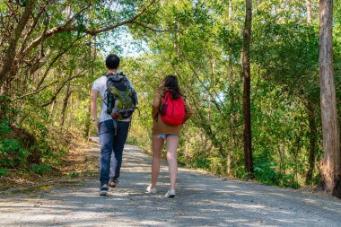 Asyalı çift yeşil ormanda birlikte yol alırken eğleniyor.