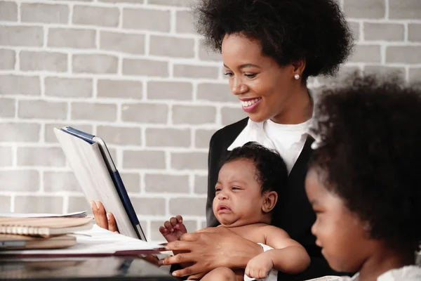 African american mother holding her baby boy on hands while work — Stock Photo, Image