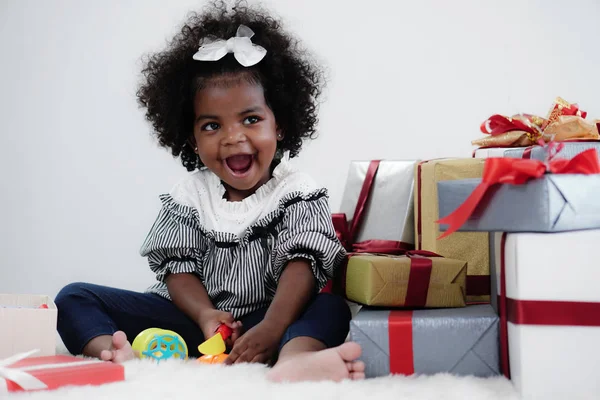 Black girl child playing toy from present box in white room — 스톡 사진