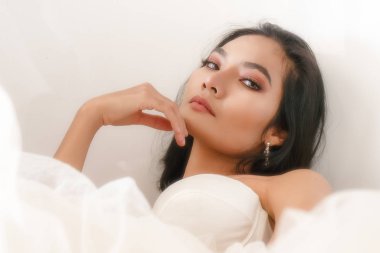 Beyaz gelinlik giymiş Asyalı kadın portresi