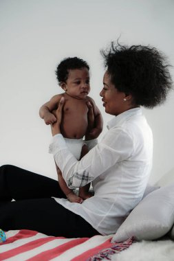 Afrikalı Amerikalı anne bebeğiyle evde vakit geçiriyor.