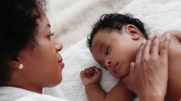 Afro-Amerikan erkek bebek anne izlerken yatakta uyuyor. — Stok fotoğraf