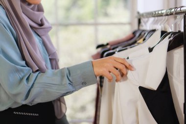 Moda tasarım dükkanında kumaş seçen bir kadın.