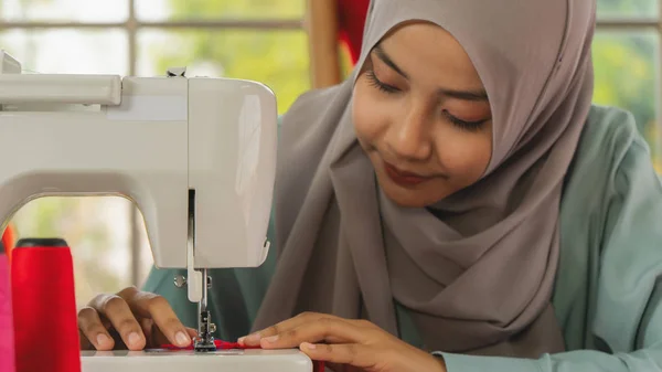 Handen van moslim mode ontwerper met behulp van naaimachine maken van haar — Stockfoto