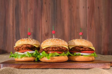 Tahta tahtada üç parça hamburgerin ahşap arka planda yemek arkaplanı.
