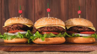 Tahta tahtada üç parça hamburgerin ahşap arka planda yemek arkaplanı.