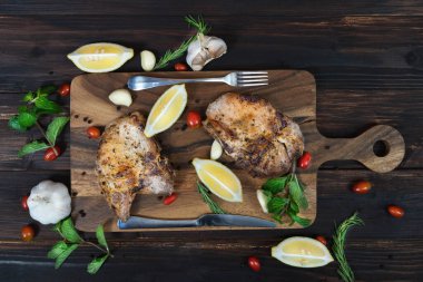 Tahtada limon, sarımsak, kekik ve karabiberli domuz pirzolası var.