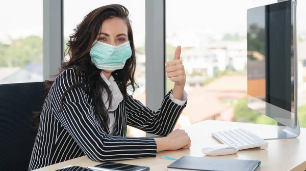 Coronavirus covid 19 enfeksiyonundan, Coronavirus covid 19 nefsi müdafaadan korumak için ofiste çalışırken maske takan iş kadınının portresi.