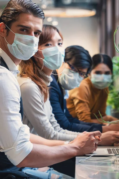 Coronavirus Covid 19 için tıbbi maske takan iş adamları birlikte çalışma alanlarında çalışıyor, Coronavirus covid 19 salgınında güvenlikte çalışıyor, seçici odaklı