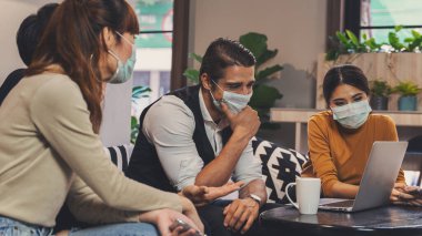 Kafkasyalı ve Asyalı iş dünyasının ortak çalışma alanı lobisinde çalışan çeşitli iş adamları ve Coronavirus covid 19 enfeksiyonundan korunmak için tıbbi maske takan herkes, Coronavirüs salgını durumunda çalışıyor.