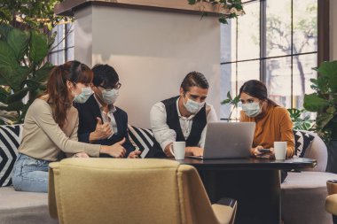 Kafkas ve Asyalı iş adamlarının iş ortaklığı lobisinde birlikte çalışmalarının iş geçmişi ve Coronavirus covid 19 enfeksiyonundan korunmak için maske takan herkes Coronavirus salgını durumunda çalışıyor.