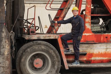 Kafkasyalı mühendis konteynır deposunda ve konteynır forklift ile kargo işinde.