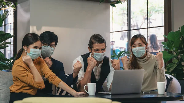 business background of businesspeople wearing medical mask for coronavirus protection having fist up together in business meeting in business lounge, working in coronavirus covid 19 outbreak situation