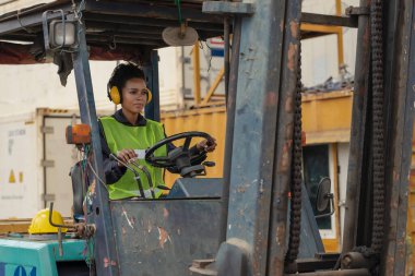 Afrika kökenli Amerikan konteynır deposu ve yükleme alanı forklift kullanan kargo işçisi.