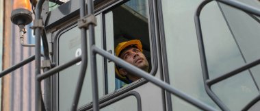 Kafkas erkek konteynır forklift sürücüsü konteynır ve kargo deposundaki sürücü kabininde forklift kullanıyor.