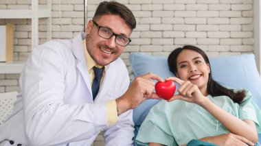 Kafkasyalı kardiyoloji doktoru ve Asyalı hasta kalp krizi önleme kampanyası konseptini bir arada tutuyorlar.