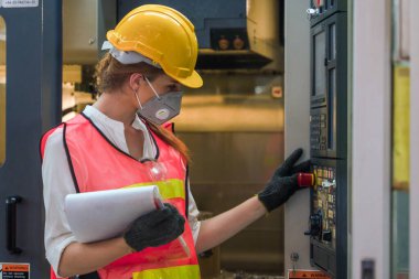 Metal üretim fabrikasında fabrika montaj hattı kontrolörünün bilgisayarlı kontrol panelini kuran endüstriyel ya da fabrika mühendisi ve denetçisi