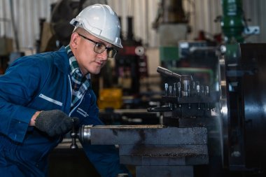Metal parçası imalat ve atölye fabrikasında makine parçası yapmak için torna kullanan Kafkas makine mühendisinin endüstriyel arka planı