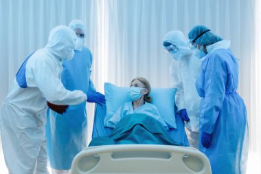 Kafkasyalı üst düzey koronavirüs kovid 19 enfeksiyonlu hasta karantina altındaki hastane odasında yatıyor. Doktorlar ve sağlık personeli, tedavi için Coronavirus covid-19 hastalığının belirtilerini gösteriyor.