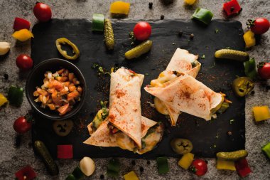 Meksika mutfağında tavuk ve peynirli dürümler var. Koyu tonda ve seçici bir şekilde seçilmiş.