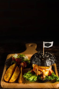 Amerikan yemek arka planında, siyah sığır eti, barbekü sosu, ahşap tabakta, koyu tonda, ince odaklı.