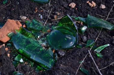 Yeşil şişe parçaları ve tuğla yere.