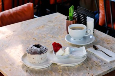 Mermer masada sufle, dondurma ve çilek. Sui soslu kahve..