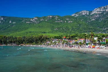 Türkiye 'nin Mugla ilçesinde Akyaka plajı, arka planda Sakar dağları ve insanlar.