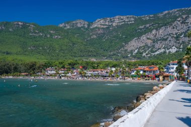 Türkiye 'nin Mugla ilçesinde Akyaka plajı, arka planda Sakar dağları ve insanlar.
