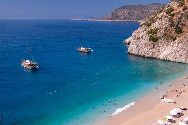 Kas, Antalya 'daki Cennet Sahili - Türkiye. Kaputaj Kemer Antalya sahilinde kapalı şemsiyeli boş bir sahil..