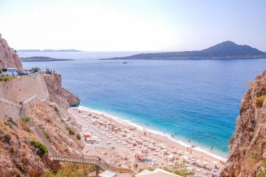 Kas, Antalya 'daki Cennet Sahili - Türkiye. Kaputaj Kemer Antalya sahilinde kapalı şemsiyeli boş bir sahil..