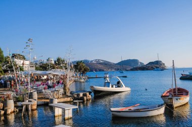 Gumusluk, Bodrum sahilindeki restoran ve bougainvillea çiçekleri. Güzel Ege Denizi yakınlarındaki Bodrum kasabasında renkli sandalyeler, masalar ve çiçekler.
