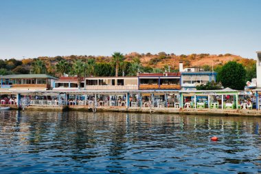 Gumusluk, Bodrum sahilindeki restoran ve bougainvillea çiçekleri. Güzel Ege Denizi yakınlarındaki Bodrum kasabasında renkli sandalyeler, masalar ve çiçekler.