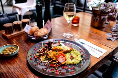 Yanında beyaz şarap eşliğinde özel yapım avokado soslu tavuk.