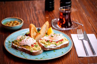 Balkonda Avokado tostlu ev yapımı haşlanmış yumurta kahvaltı için hazır. Geleneksel Türk çay ve kahvaltısı.