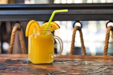 Taze sıkılmış organik portakal suyu. Özel olarak hazırlanmış portakal suyu. Tahta masaya dekore edilmiş egzotik alkollü kokteyller. Tahtada turuncu ve sarı pembe meşrubatlar.