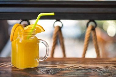 Taze sıkılmış organik portakal suyu. Özel olarak hazırlanmış portakal suyu. Tahta masaya dekore edilmiş egzotik alkollü kokteyller. Tahtada turuncu ve sarı pembe meşrubatlar.