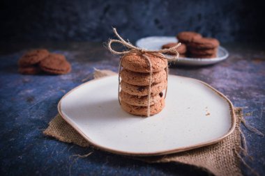 Güzel istiflenmiş kurabiyeler ve kırsal masada çikolata. Çikolata parçalı kurabiyeler Vintage Renkli.