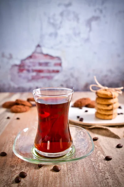 Ahşap masada güzel istiflenmiş kurabiyeli geleneksel Türk çayı. Çikolata parçalı kurabiyeler Vintage Renkli. Üst görüntü fotoğrafı.