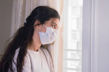Koronavirüse karşı koruyucu maske takan Asyalı kadın doktor. Evde karantina günleri. Evde Kal.