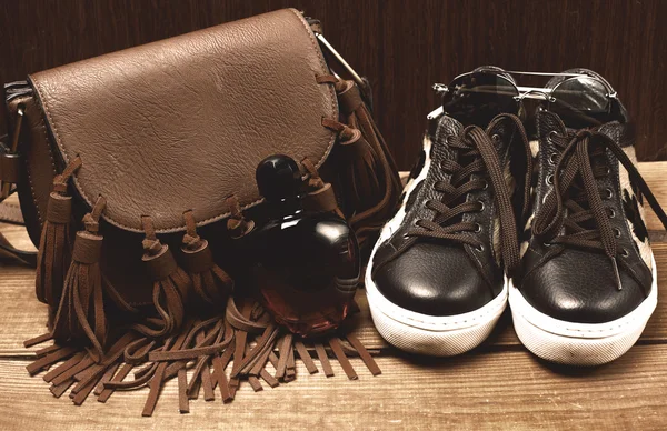 Stiefel und braune Tasche auf Holztisch — Stockfoto